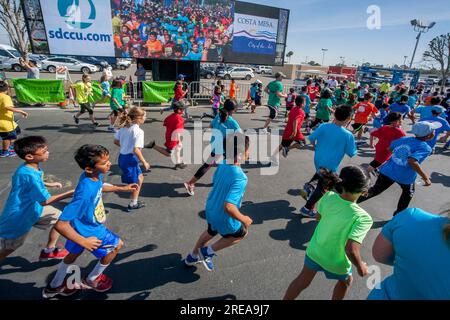 Costa Mesa, California, USA. 5th May, 2018. 10-year-old multiracial runners pass a Jumbotron video image of themselves as the race begins at a community track event in Costa Mesa, CA. (Credit Image: © Spencer Grant/ZUMA Press Wire) EDITORIAL USAGE ONLY! Not for Commercial USAGE! Stock Photo