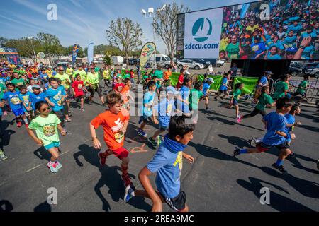 Costa Mesa, California, USA. 5th May, 2018. 10-year-old multiracial runners pass a Jumbotron video image of themselves as the race begins at a community track event in Costa Mesa, CA. (Credit Image: © Spencer Grant/ZUMA Press Wire) EDITORIAL USAGE ONLY! Not for Commercial USAGE! Stock Photo