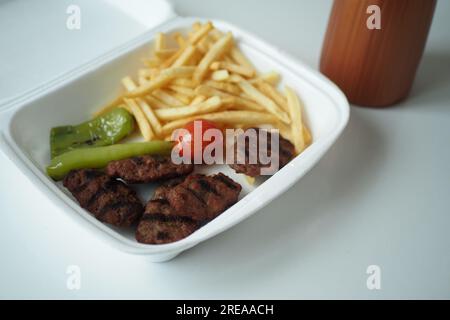 Kebab, traditional turkish meat food with salad in a takw away packet  Stock Photo