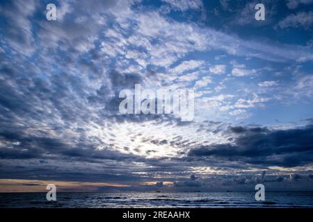 Rostock, Germany. 26th July, 2023. Cargo ships lie in the roads on the Baltic Sea before sunset, waiting to enter the seaport. The summer weather in northern Germany is cool, windy and rainy. Credit: Jens Büttner/dpa/Alamy Live News Stock Photo