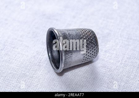 Metal thimble for sewing. Antique copper thimble on a white background. Stock Photo