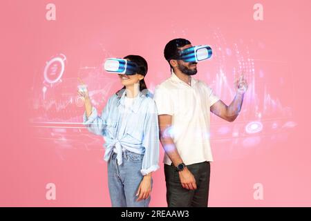 Happy young man and woman using VR glasses, pink background Stock Photo