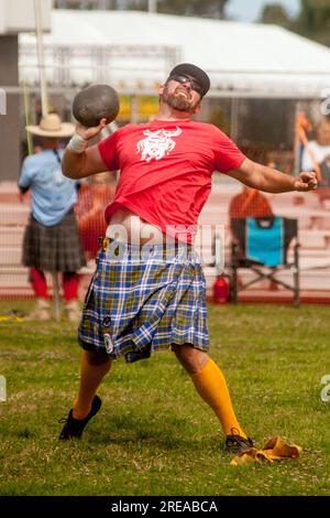 Costa Mesa, California, USA. 26th May, 2018. Kilt and crested T-shirt fly as a grimacing contestant prepares to toss the 22-pound Braeman Stone at Highland Games in Costa Mesa, CA. (Credit Image: © Spencer Grant/ZUMA Press Wire) EDITORIAL USAGE ONLY! Not for Commercial USAGE! Stock Photo