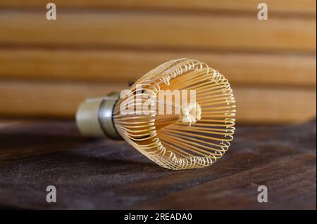 Close-up of bamboo green tea whisk. Bamboo matcha whisk. Wooden background. Side view. Stock Photo