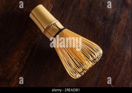 Close-up of bamboo green tea whisk. Bamboo matcha whisk. View from above. Wooden background. Stock Photo