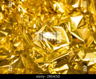 defocused crumpled gold foil, fashion texture background. High quality photo Stock Photo