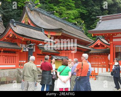 Tourists, pilgrims & Shinto worshippers are drawn to the orange buildings of Nachi Taisha Grand Shrine, one of the Three Grand Shrines of Kumano. Stock Photo