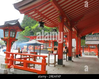 Tourists, pilgrims & Shinto worshippers are drawn to the orange buildings of Nachi Taisha Grand Shrine, one of the Three Grand Shrines of Kumano. Stock Photo