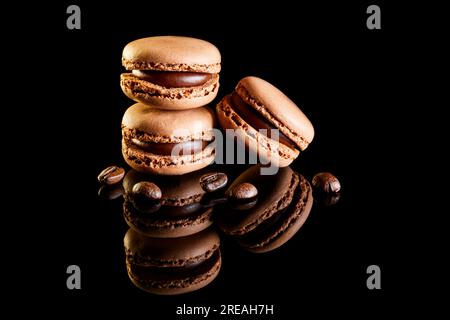 Flavoured coloured macarons on a reflective surface with coffee beans Stock Photo