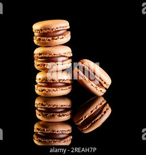 Stack of flavoured coloured macarons on a reflective surface with coffee beans Stock Photo