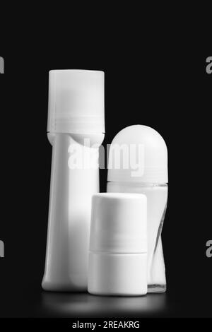 Set of white antiperspirant deodorant roll-on, isolated on black background, mockups of white plastic packaging for personal hygiene, containers Stock Photo