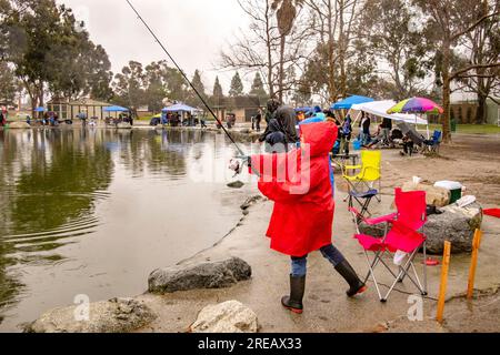 A red-coated Asian American girl swings her fishing rod as she casts for  catfish at a fishing derby in Fountain Valley, CA Stock Photo - Alamy