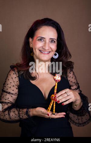 Coaching woman in black clothing holding the giraffe symbol of non-violent communication. Isolated on brown background. Stock Photo