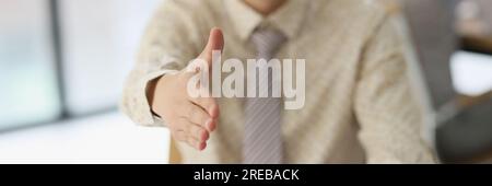 Businessman extending his hand for handshake with partner in office Stock Photo