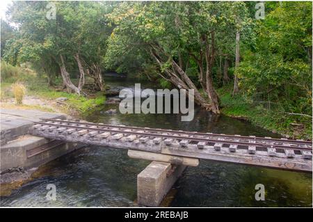 Little Mulgrave River, Peaceful Tree lined river scene, with railway bridge for Sugar Cane haulage, Cairns, Australia. Stock Photo