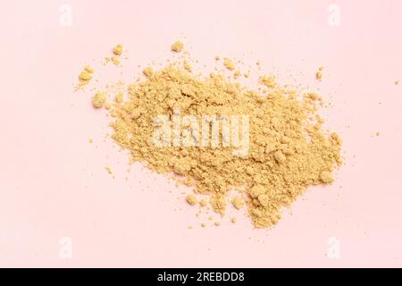 Heap of ginger powder on pink background Stock Photo