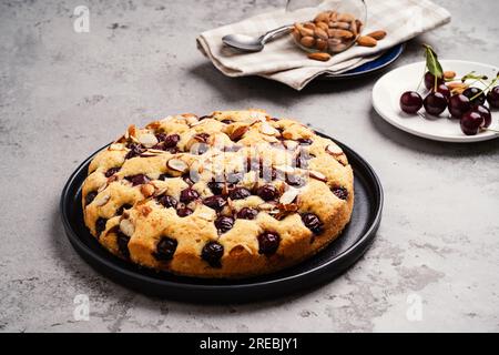 Homemade cherry cake with almond nuts, summer fruit dessert, close up Stock Photo