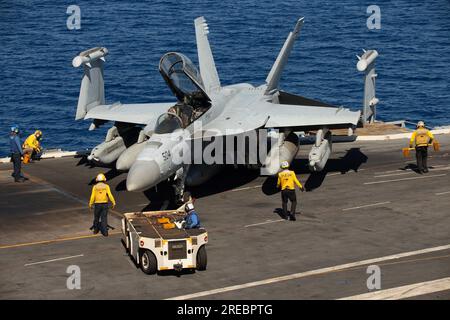 At Sea. 16th July, 2023. Sailors assigned to the worldÃs largest aircraft carrier USS Gerald R. Fords (CVN 78) air department, transport an E/A-18G Growler, attached to the ''Gray Wolves'' of Electronic Attack Squadron (VAQ) 142, on the flight deck, July 16, 2023. VAQ 142 is deployed aboard CVN 78 as part of Carrier Air Wing (CVW) 8. The Gerald R. Ford Carrier Strike Group (GRFCSG) is participating in Neptune Strike, a multiyear effort focused on harmonizing U.S. and NATO planning teams to transfer command and control of Allied naval and amphibious forces to STRIKFORNATO, in order to provide Stock Photo