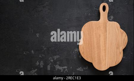 Wooden cutting board on dark background, banner with copy space. Concept of preparing food Stock Photo