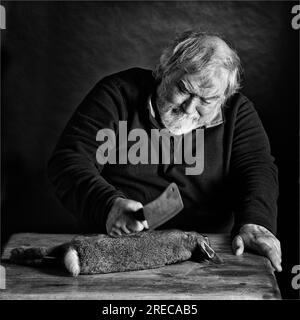 Man chopping up wild rabbit meat Stock Photo