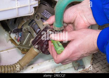 A man screwdriver with a washing machine motor Stock Photo