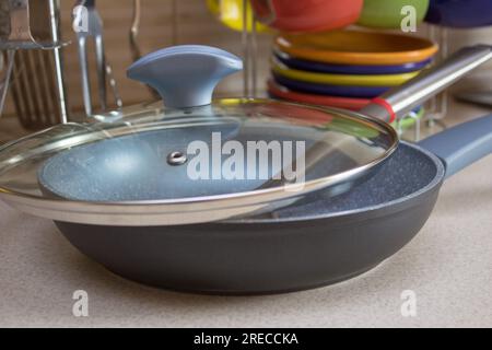 A new frying pan on the kitchen furniture Stock Photo