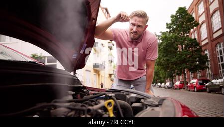 Broken Down Car. Frustrated Man Looking At Smoke Stock Photo