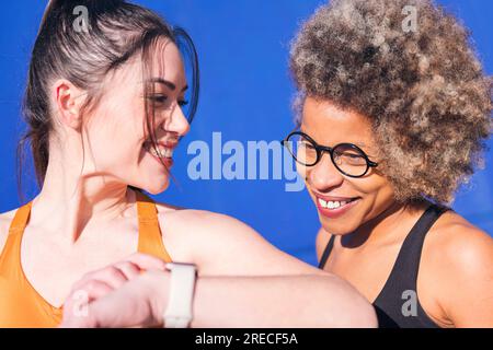 two friends using a smart watch practicing sports Stock Photo