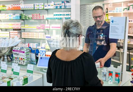 Berlin, Germany. 24th July, 2023. ILLUSTRATION - A woman is shopping in a pharmacy. (posed shot) Credit: Jens Kalaene/dpa/Alamy Live News Stock Photo