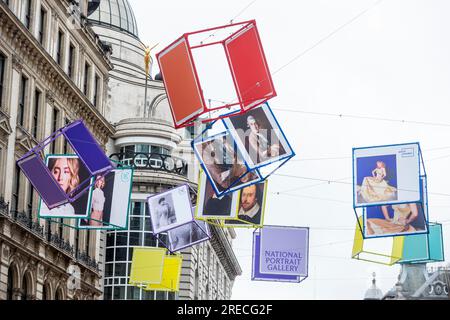 London, UK.  27 July 2023.  ‘Art Reframed’, launches with decorated cubes hanging overhead in Coventry Street, just off Leicester Square, ahead of ‘Art of London’s Summer Season 2023: The Art of Entertainment’.  Portraits of famous cultural icons, including Elton John, Olivia Colman, Judi Dench, William Shakespeare, Saoirse Ronan, Dusty Springfield and Kate Bush, are seen on the cubes in the public art initiative developed in partnership with the recently reopened National Portrait Gallery (NPG).  Credit: Stephen Chung / Alamy Live News Stock Photo