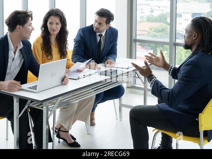 Job interview concept. Employer and diverse hr team doing job interview with a black man in business office. Job candidate talks with human resources Stock Photo
