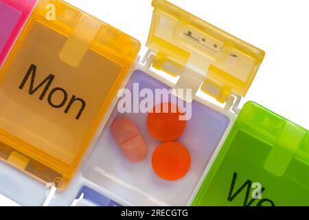Close up of Daily pill box with different colours for different days of week to put tablets pills in to act as a reminder for taking medication Stock Photo