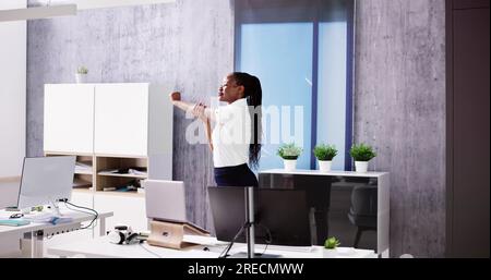 Arms Stretch Exercise Standing Near Desk In Office Stock Photo