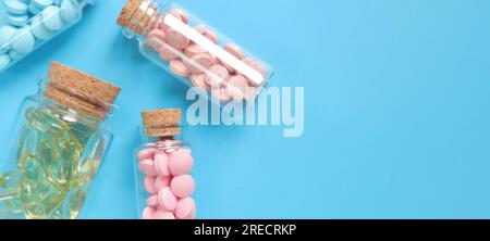 Vitamins in glass bottles on a blue background, copy space. Vitamins, painkillers, healthcare, health pills and dietary supplements. Vitamin B complex Stock Photo