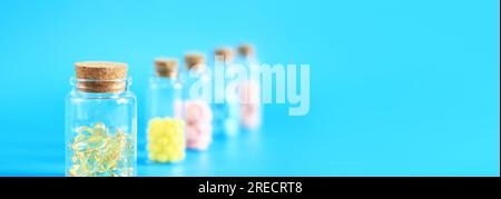 Vitamins in glass bottles on a blue background, side view, copy space. Vitamins, painkillers, healthcare, health pills and dietary supplements. Select Stock Photo