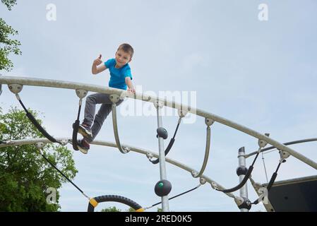 A boy child having fun daring climbs the playground Stock Photo