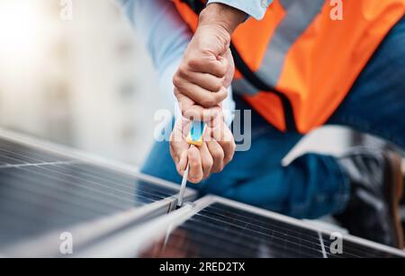 Solar panels, tool and closeup of male engineer doing maintenance or repairs with screwdriver. Renovation, handyman and zoom of an industrial worker Stock Photo