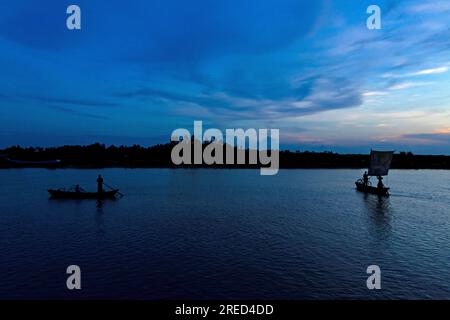 Munshiganj, Dhaka, Bangladesh. 27th July, 2023. A sailboat is silhouetted against the blue sky with clouds during twilight as people return to their homes after a workday in Munshiganj, Bangladesh. (Credit Image: © Joy Saha/ZUMA Press Wire) EDITORIAL USAGE ONLY! Not for Commercial USAGE! Stock Photo