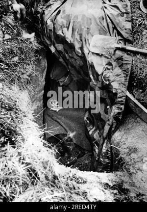 A soldier writes a letter in a hole in the ground on the Eastern Front. [automated translation] Stock Photo