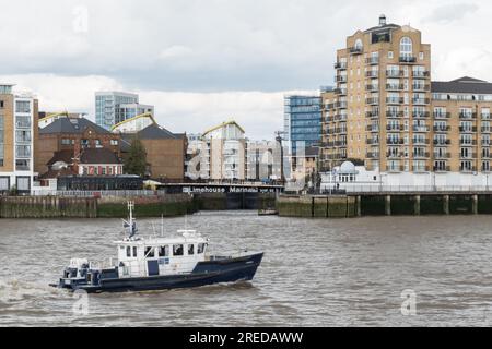 A Port of London Authority launch passing in front of the entrance to Limehouse Marina on the River Thames at Limehouse, London, E1, England, U.K. Stock Photo