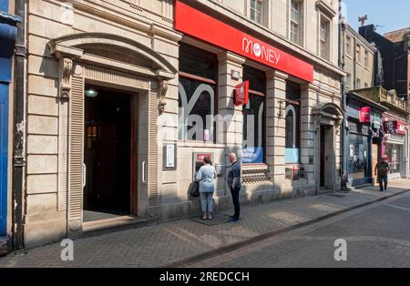 Virgin Money Bank branch and person using ATM cash machine on the high street Scarborough North Yorkshire England UK United Kingdom GB Great Britain Stock Photo