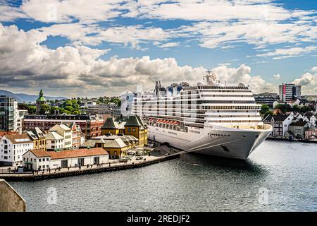 The 92,627 GRT MSC Poesia dwarfs the city seafront of Stavanger, Norway when it delivers around 3,000 daytrippers to boost the local economy. Stock Photo