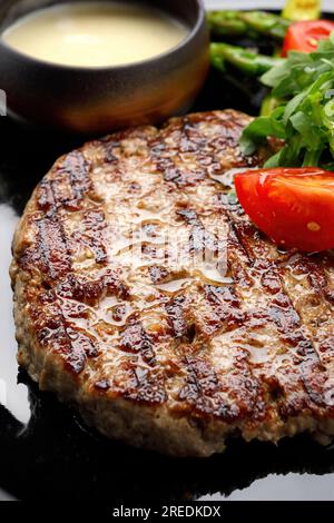 grilled pork steak with sauce, arugula and tomatoes Stock Photo