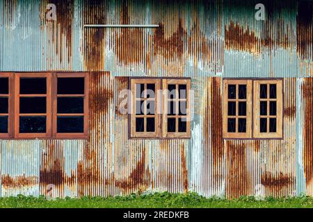 Facade house with old zinc wall. Beautiful vintage galvanized sheet make nice exterior of home. Rusty galvanized iron sheet with materials to make hou Stock Photo