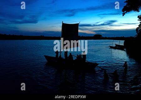 Munshiganj, Dhaka, Bangladesh. 27th July, 2023. A sailboat is silhouetted against the blue sky with clouds during twilight as people return to their homes after a workday in Munshiganj. (Credit Image: © Joy Saha/ZUMA Press Wire) EDITORIAL USAGE ONLY! Not for Commercial USAGE! Stock Photo