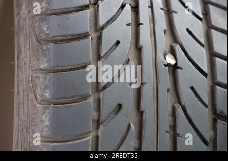 Metal pin head in new tyre macro close up view Stock Photo