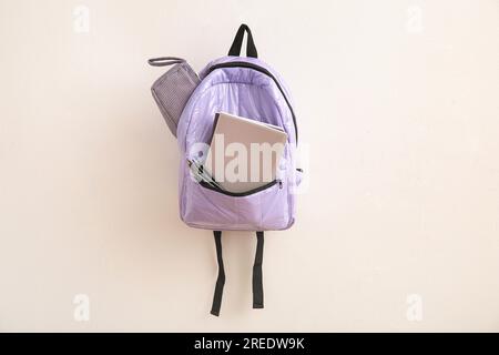 Lilac school backpack with stationery on light background Stock Photo