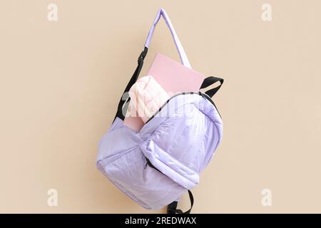 Lilac school backpack with stationery on beige background Stock Photo