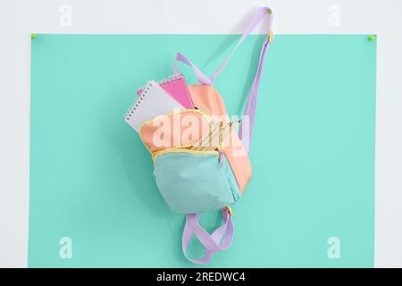 Color school backpack with stationery on turquoise background Stock Photo