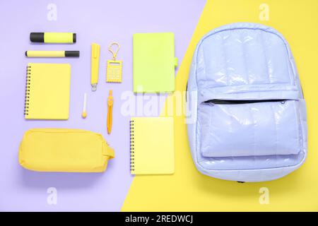 Lilac school backpack with different stationery on color background Stock Photo